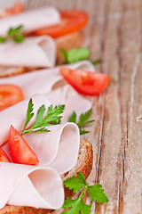 Image showing bread with sliced ham, fresh tomatoes and parsley