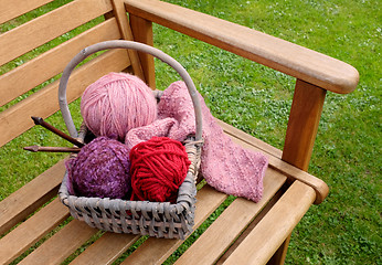 Image showing Basket of knitting and yarns on a bench