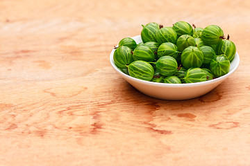 Image showing Close-Up Of Gooseberries In Vintage White Dish On Wooden Table