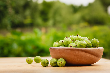 Image showing Close-Up Of Gooseberries In Vintage Wooden Bowl On Wooden Table