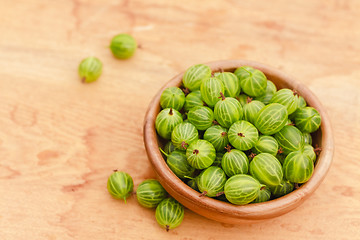 Image showing Close-Up Of Gooseberries In Vintage Wooden Bowl On Wooden Table