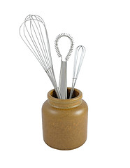 Image showing Three metal whisks in a brown ceramic jar