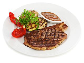 Image showing Grilled steaks, baked potatoes and vegetables on white plate.