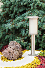 Image showing Solar-powered lamp on garden background.