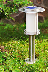 Image showing Solar-powered lamp on garden background.