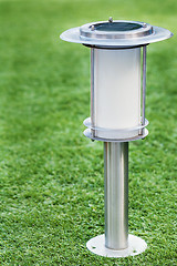 Image showing Solar-powered lamp on green grass background. 