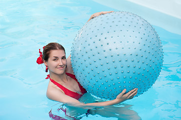 Image showing Beautiful girl with blue ball in swimming pool. 