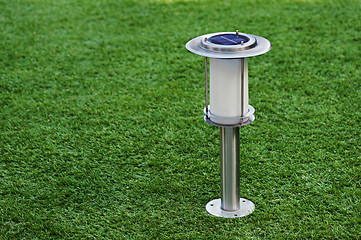 Image showing Solar-powered lamp on green grass background.