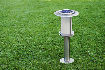 Image showing Solar-powered lamp on green grass background.