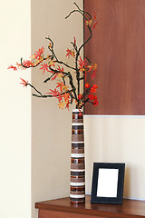 Image showing Autumn arrangement in a vase on the table and photoframe.