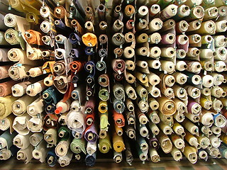 Image showing wall full of rolls of fabrics
