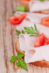 Image showing bread with sliced ham, fresh tomatoes and parsley 