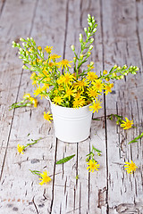 Image showing wild yellow flowers in bucket 