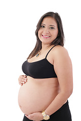 Image showing hispanic pregnant woman smiling and touching her belly