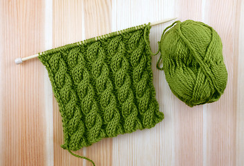 Image showing Green cable stitch knitting with a ball of yarn