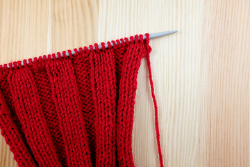 Image showing Red knitting on the needle in rib stitch