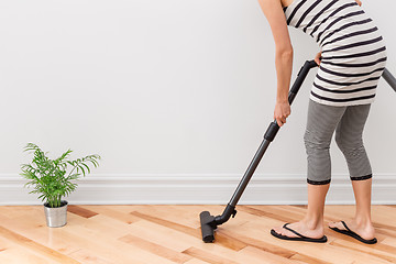 Image showing Woman vacuum cleaning the room