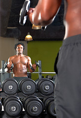 Image showing Mirror reflection of two men exercising in gym