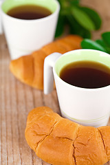 Image showing two cups of tea and fresh croissants 