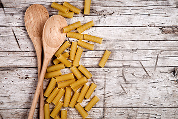 Image showing raw macaroni and wooden spoons 