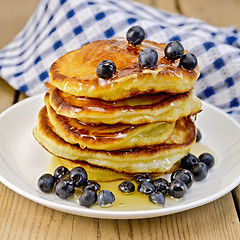 Image showing Flapjacks with blueberries and honey on the board