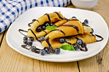 Image showing Pancakes with blueberries and chocolate syrup