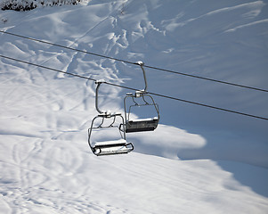 Image showing Two chair-lift with snowdrift in sun morning