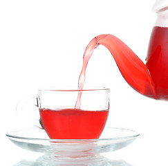 Image showing Tea being poured into glass tea cup isolated