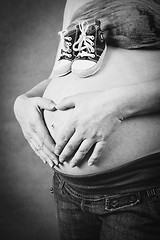 Image showing pregnant woman with a child shoe and hand heart shape