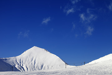 Image showing Ski slope with ropeway at sunny winter day