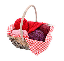 Image showing Pink, purple and red yarn with knitting in a basket