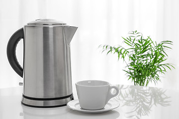 Image showing White cup and electric kettle on the table