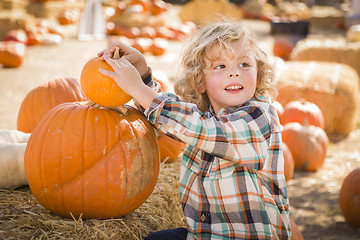 Image showing Little Boy Sitting and Holding His Pumpkin at Pumpkin Patch
