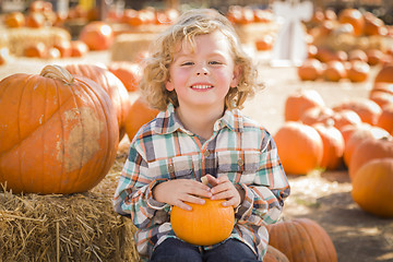 Image showing Little Boy Sitting and Holding His Pumpkin at Pumpkin Patch
