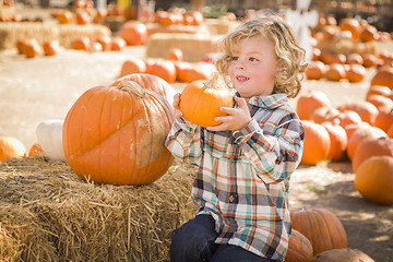 Image showing Little Boy Sitting and Holding His Pumpkin at Pumpkin Patch
