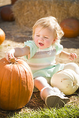 Image showing Adorable Baby Girl Holding a Pumpkin at the Pumpkin Patch
