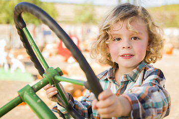 Image showing Adorable Young Boy Playing on an Old Tractor Outside