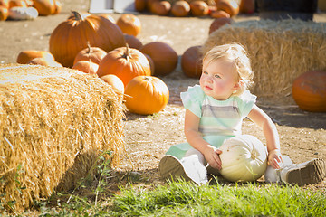 Image showing Adorable Baby Girl Holding a Pumpkin at the Pumpkin Patch
