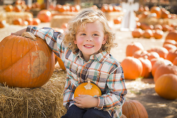 Image showing Little Boy Sitting and Holding His Pumpkin at Pumpkin Patch
