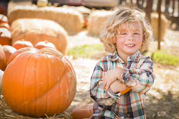 Image showing Little Boy Sitting and Holding His Pumpkin at Pumpkin Patch
