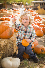 Image showing Little Boy Sitting and Holding His Pumpkin at Pumpkin Patch
