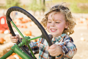 Image showing Adorable Young Boy Playing on an Old Tractor Outside