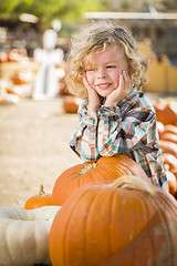 Image showing Little Boy Smiles While Leaning on Pumpkin at Pumpkin Patch