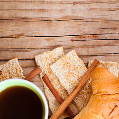 Image showing cup of coffee, crackers and fresh croissant for breakfast