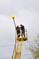 Image showing Electricians repair a streetlight.