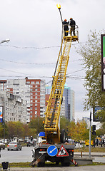 Image showing Electricians repair a streetlight.
