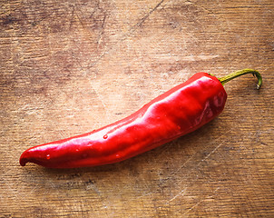 Image showing Red peppers on old wooden table