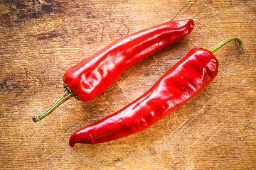 Image showing Red peppers on old wooden table