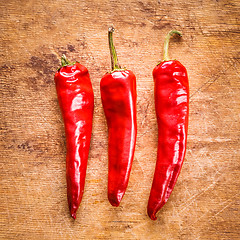 Image showing Red peppers on old wooden table