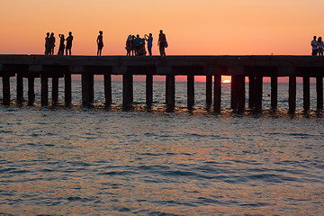 Image showing People on the old sea pier at sunset